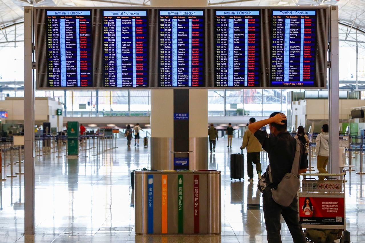 Un pasajero mira una pantalla de información que muestra que casi todos los vuelos han sido cancelados debido al súper tifón Saola, en el Aeropuerto Internacional de Hong Kong, en Hong Kong, el viernes 1 de septiembre de 2023