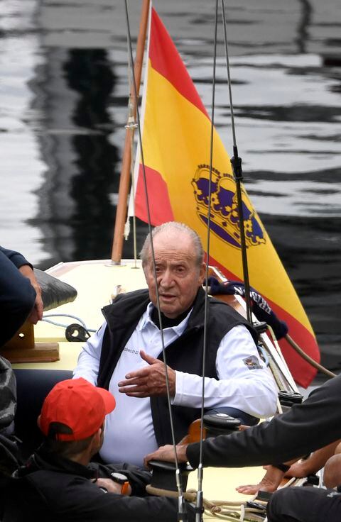 El ex rey de España, Juan Carlos I, habla con los miembros de la tripulación mientras aborda un barco en Sanxenxo, al norte de España, el 20 de abril de 2023.