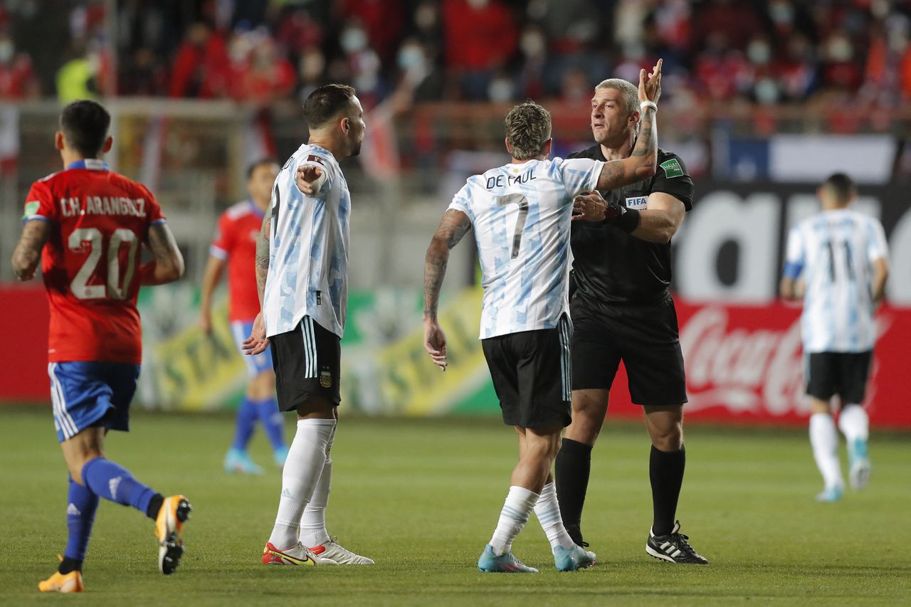 Argentina's Rodrigo De Paul (C) argues with Brazilian referee Anderson Daronco (R) during the South American qualification football match for the FIFA World Cup Qatar 2022 between Chile and Argentina at Zorros del Desierto Stadium in Calama, Chile on January 27, 2022. (Photo by Javier Torres / POOL / AFP)