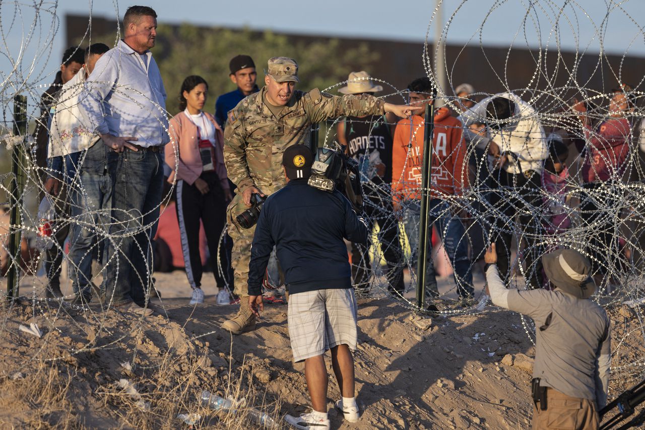 Un soldado de la Guardia Nacional de Texas impide que los periodistas se acerquen a los migrantes que cruzaron desde México el 9 de mayo de 2023 en El Paso, Texas.