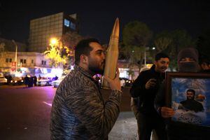Un manifestante besa una réplica de un casquillo de bala mientras otros se reúnen en la Plaza Palestina en Teherán el 14 de abril de 2024, después de que Irán lanzara un ataque con aviones no tripulados y misiles contra Israel