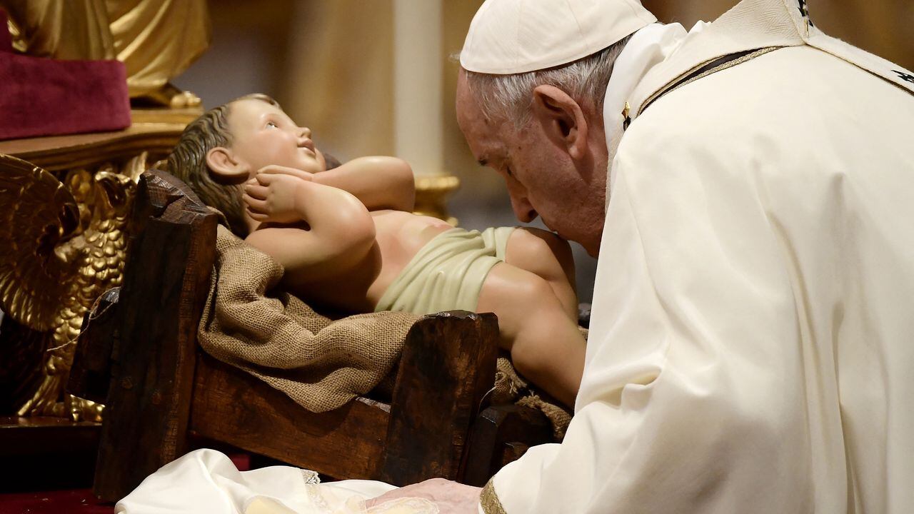 El Papa Francisco besa una figura del niño Jesús durante la misa de Nochebuena en la Basílica de San Pedro en el Vaticano, el 24 de diciembre de 2021.