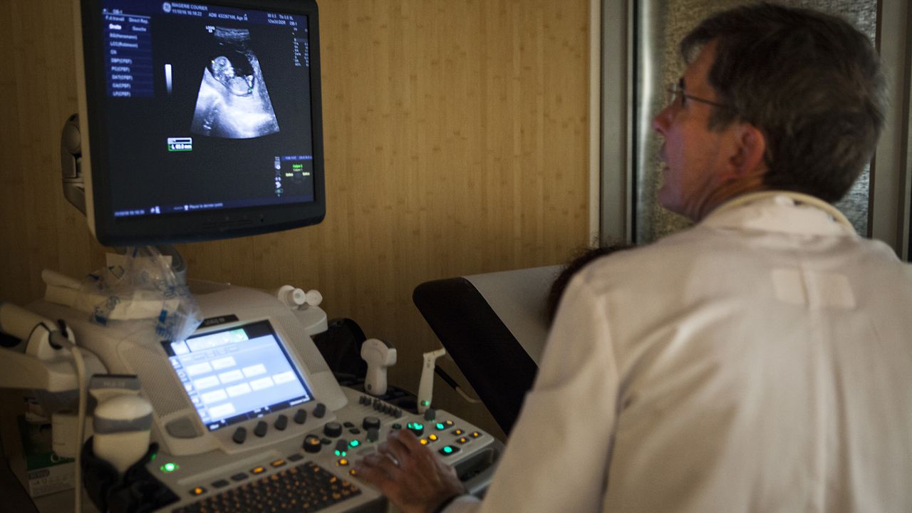 Radiólogo analiza el vientre de una mujer en embarazo. Imagen de referencia