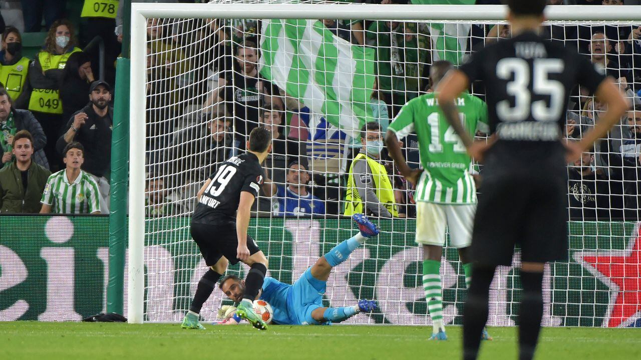 Real Betis' Chilean goalkeeper Claudio Bravo (down) stops a penalty by Eintracht Frankfurt's Colombian forward Rafael Santos Borre Maury during the UEFA Europa League round of 16 first league football match between Real Betis and Eintracht Frankfurt at the Benito Villamarin stadium in Seville on March 9, 2022. (Photo by CRISTINA QUICLER / AFP)