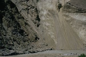 Earth and rock pours into the Indus River, as seen from the Karakoram Highway.