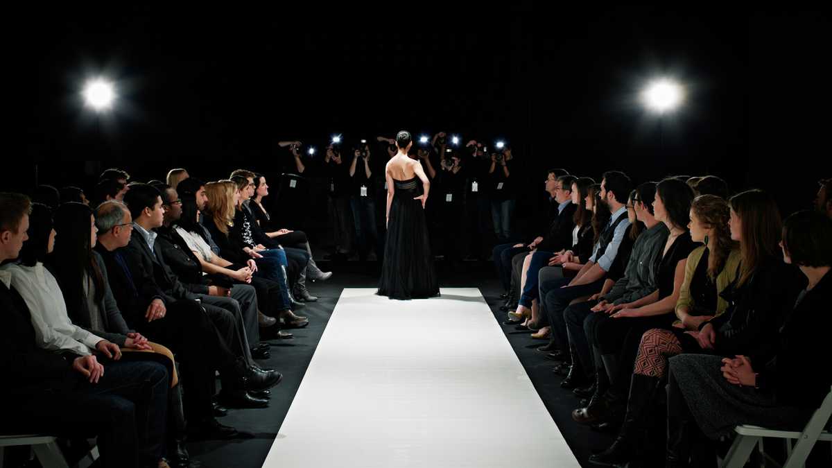 Model in gown at end of catwalk posing