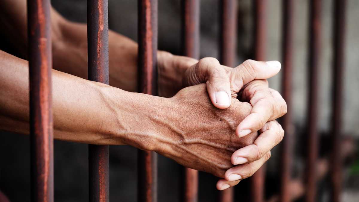 Manos de la prisionera en la cárcel
