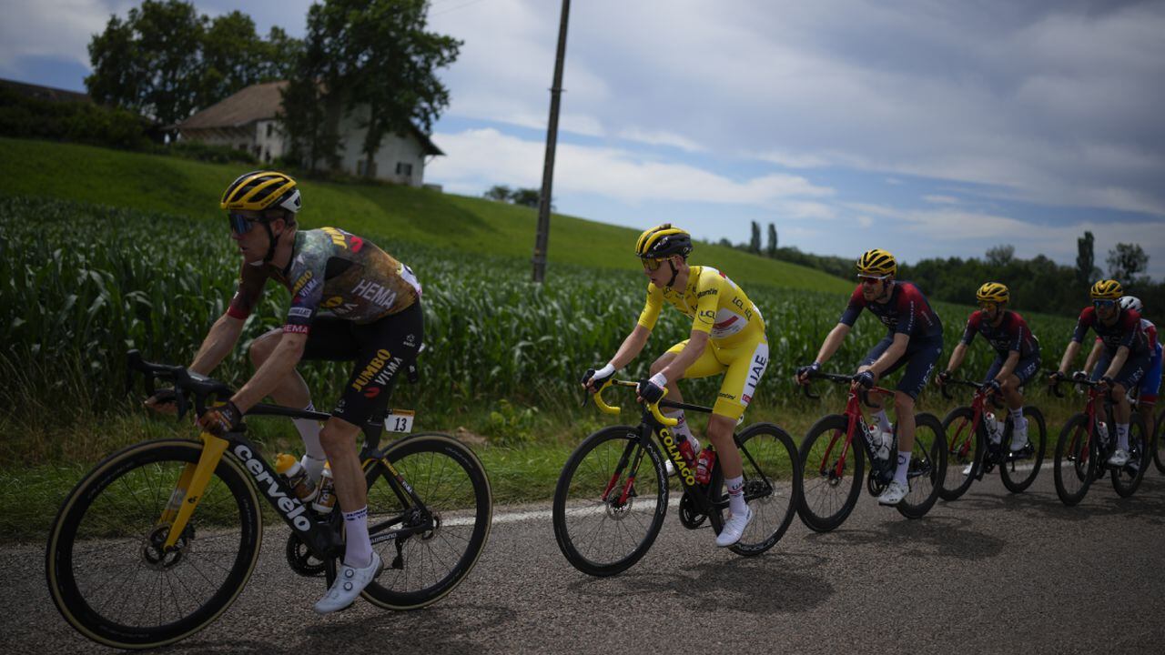 Slovenia's Tadej Pogacar, wearing the overall leader's yellow jersey, follows Netherland's Steven Kruijswijk, after several riders where distanced following a crash in the pack during the eighth stage of the Tour de France cycling race over 186.5 kilometers (115.9 miles) with start in Dole, France, and finish in Lausanne, Switzerland, Saturday, July 9, 2022. (AP/Daniel Cole)