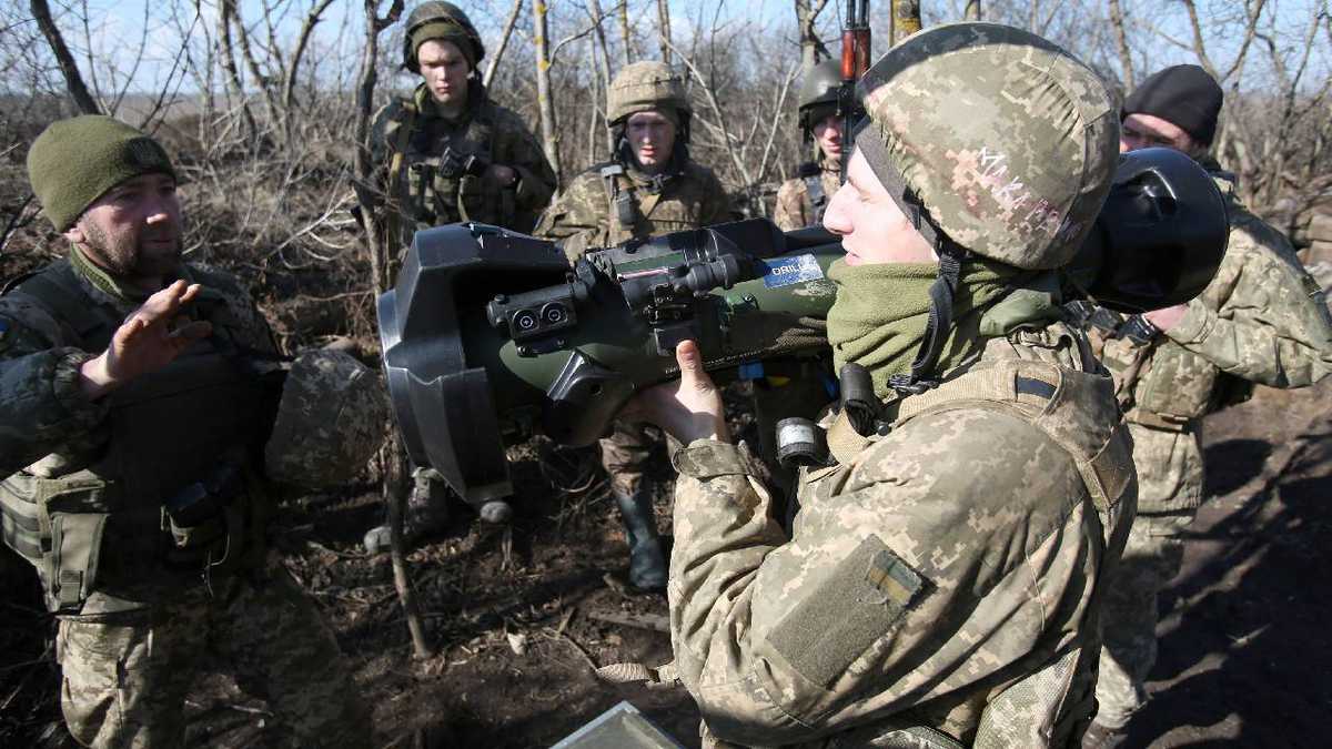 Soldados de las fuerzas militares ucranianas en primera línea con separatistas respaldados por Rusia cerca de la aldea de Novognativka, región de Donetsk, examinan un misil guiado antitanque portátil sueco-británico NLAW que fue transferido a las unidades como parte de la asistencia técnico-militar británica, el 21 de febrero de 2022.
Anatolii STEPANOV / AFP