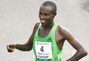 El atleta keniata Geoffrey Mutai sonríe tras cruzar la meta como ganador de la Media Maraton de Bogotá.