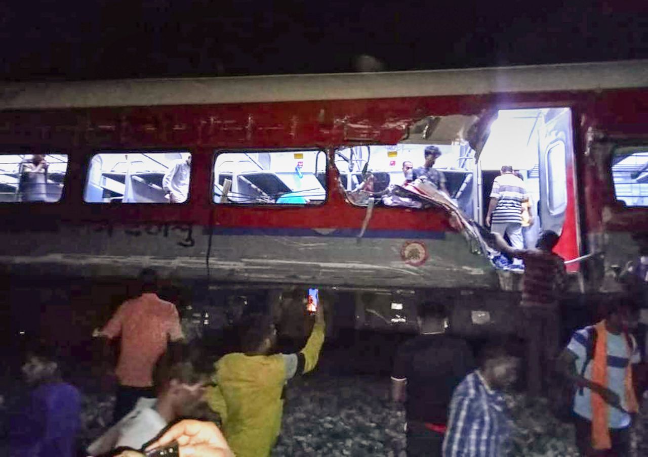 La gente inspecciona el sitio de los trenes de pasajeros que descarrilaron en el distrito de Balasore, en el estado de Orissa, en el este de India, el viernes 2 de junio de 2023.