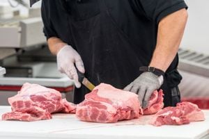carnicero masculino irreconocible preparando carne cruda supermercado