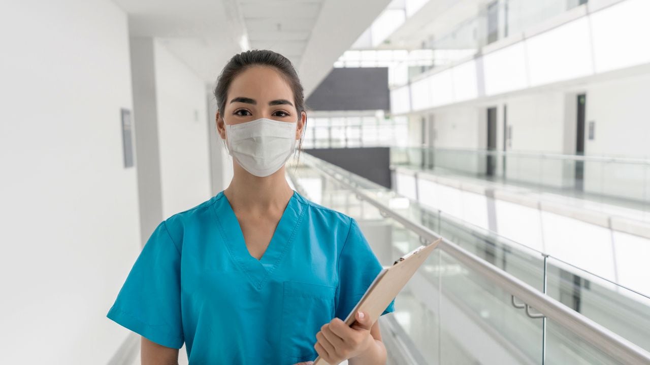 Retrato de una feliz enfermera latinoamericana trabajando en el hospital y mirando a la cámara sonriendo