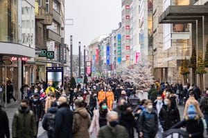 Numerous pedestrians walk through the  decorated city centre in Duesseldorf, Germany, Saturday, Dec.12, 2020. The ministry fears a particularly strong run on customers in view of the debate about an imminent lockdown in retail. (Marcel Kusch/dpa via AP)