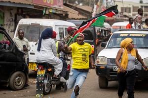 Un partidario corre por las calles vistiendo una camiseta que muestra a William Ruto y ondeando la bandera nacional, en el barrio de Kibera de Nairobi, Kenia, el lunes 5 de septiembre de 2022.. Foto AP/Ben Curtis