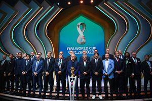 Los entrenadores posan frente al trofeo de la Copa del Mundo durante el sorteo de la Copa del Mundo de 2022 en Qatar en el Centro de Convenciones y Exposiciones de Doha el 1 de abril de 2022. (Photo by FRANCK FIFE / AFP)