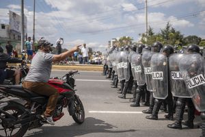 A demonstrator confronts the police during a national strike, in Guatemala City, Tuesday, Oct. 10, 2023. People are protesting to support President-elect Bernardo Arévalo after Guatemala's highest court upheld a move by prosecutors to suspend his political party over alleged voter registration fraud. (AP Photo/Santiago Billy)