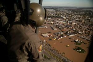 Un militar observa desde un helicóptero las calles inundadas de la ciudad de El Dorado do Sul, estado de Rio Grande do Sul, Brasil, el 8 de mayo de 2024.