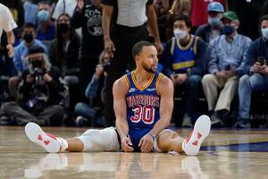 Stephen Curry, sentado sobre la duela del Pepsi Center en Denver donde consiguió su triple número 3000