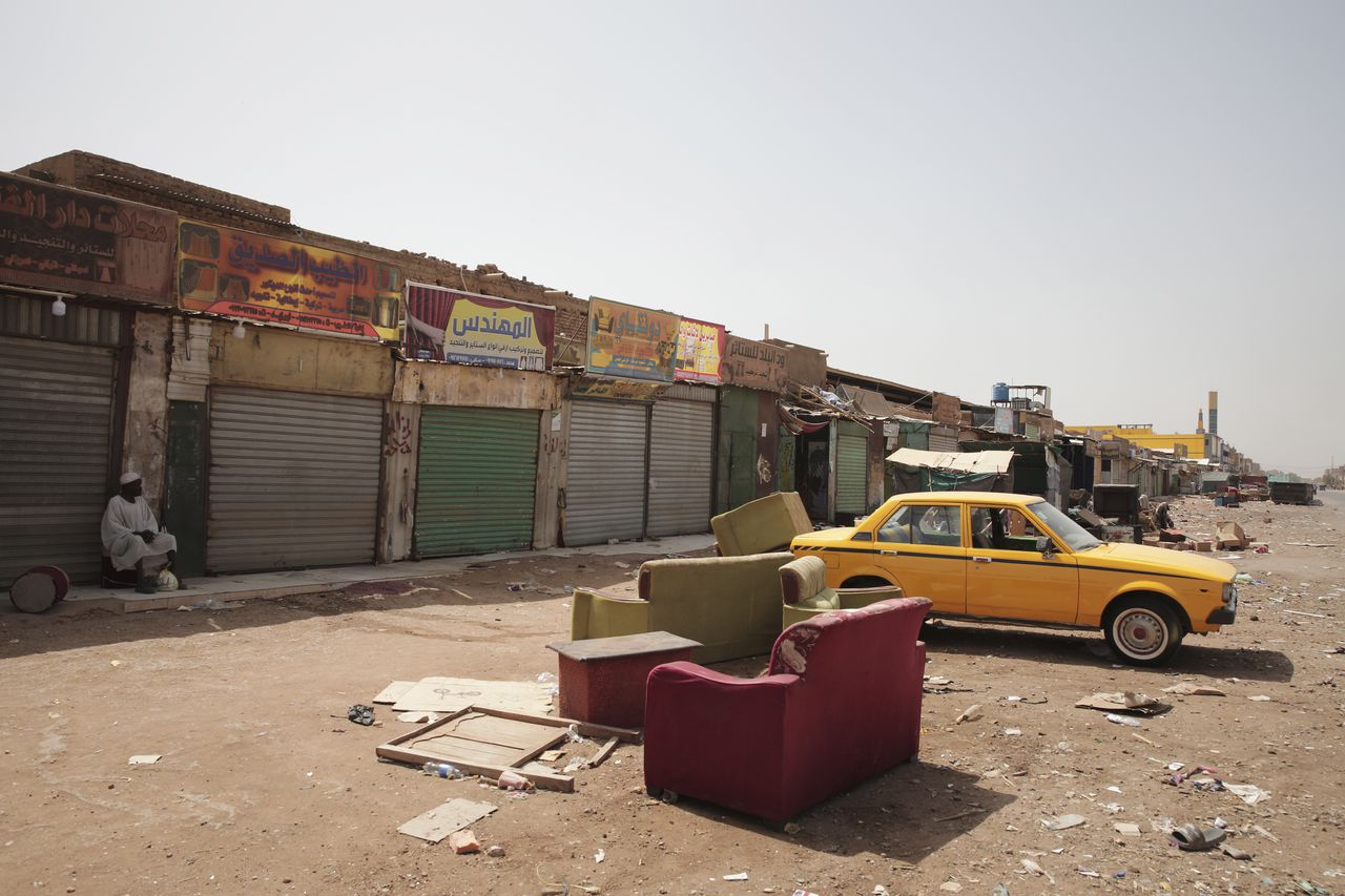 Un hombre sentado frente a tiendas cerradas en Jartum, Sudán, el lunes 17 de abril de 2023.