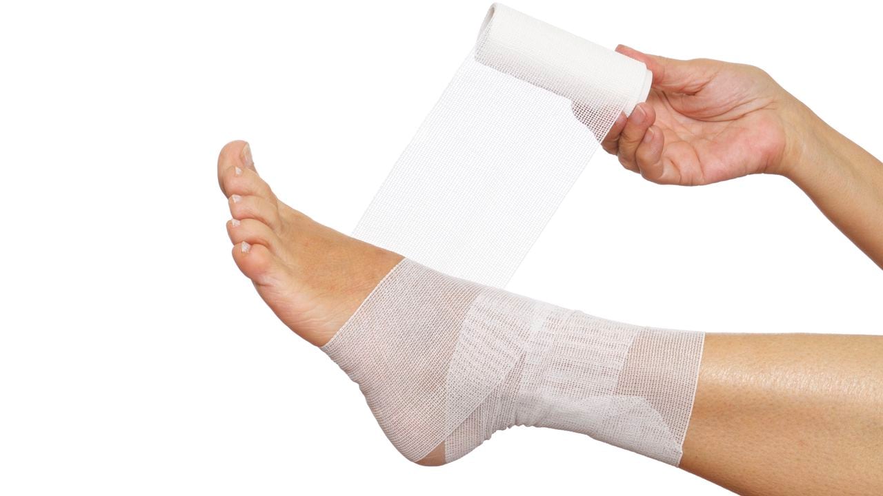 Woman self bandaging ankle