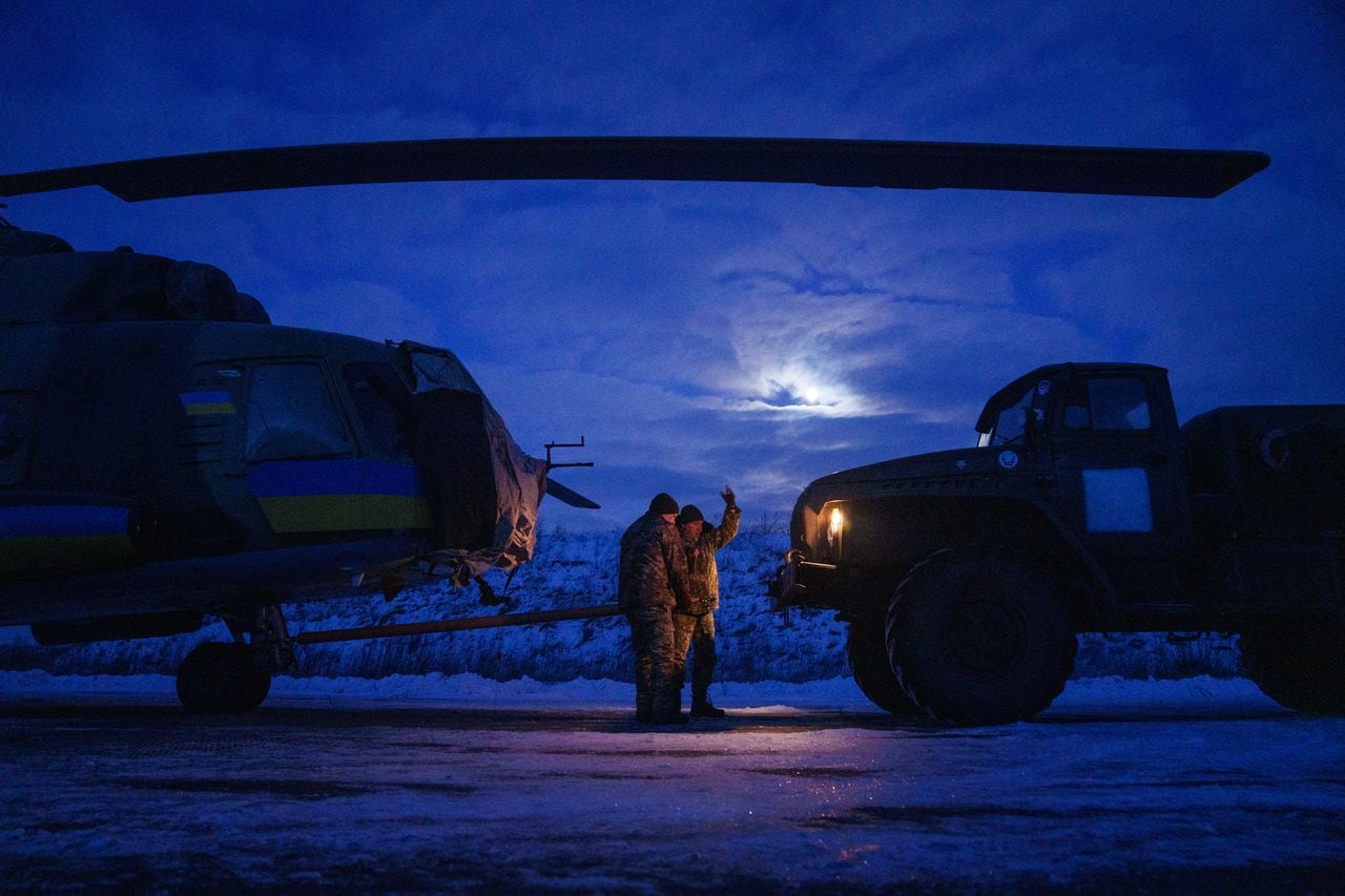 Los miembros de la tripulación militar ucraniana de la 18.a Brigada de Aviación del Ejército Separado preparan un helicóptero Mi-8 antes de despegar en el este de Ucrania el 7 de febrero de 2023, en medio de la invasión militar de Rusia en Ucrania. (Foto de Ihor Tkachov / AFP)
