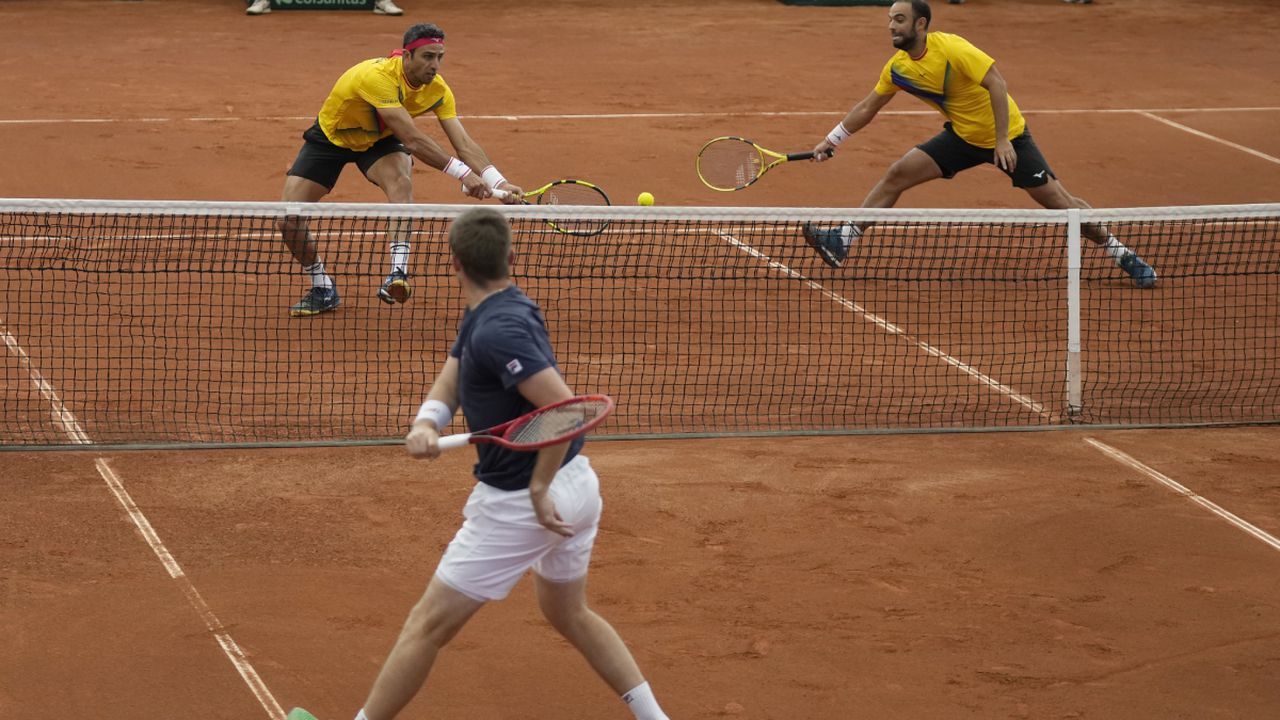 Neal Skupski of Britain, bottom, returns a ball to Robert Farah, left, and Juan Sebastian Cabal, of Colombia, during their Davis Cup qualification doubles match in Cota, Colombia, Saturday, Feb. 4, 2023. (AP/Fernando Vergara)