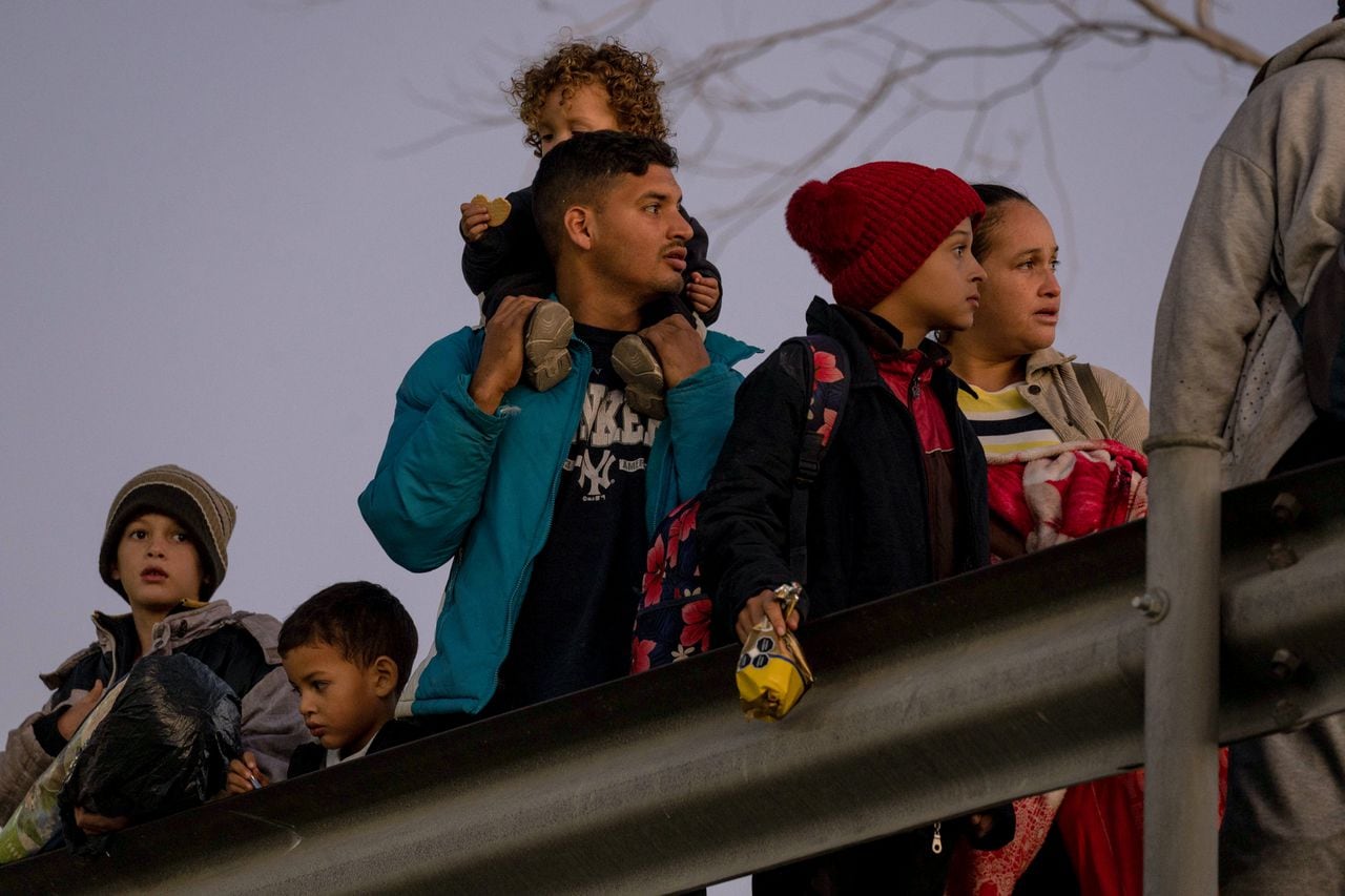 Migrantes, incluido Blaidimar, (i), de 8 años, de Venezuela, pasan la noche afuera a lo largo de la valla fronteriza entre Estados Unidos y México mientras esperan presentar solicitudes de asilo en El Paso, Texas, el 21 de diciembre de 2022
