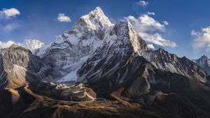 75MPix XXXXL size panorama of Mount Ama Dablam - probably the most beautiful peak in Himalayas. 
 This panoramic landscape is an very high resolution multi-frame composite and is suitable for large scale printing
Ama Dablam is a mountain in the Himalaya range of eastern Nepal. The main peak is 6,812  metres, the lower western peak is 5,563 metres. Ama Dablam means  'Mother's neclace'; the long ridges on each side like the arms of a mother (ama) protecting  her child, and the hanging glacier thought of as the dablam, the traditional double-pendant  containing pictures of the gods, worn by Sherpa women. For several days, Ama Dablam dominates  the eastern sky for anyone trekking to Mount Everest basecamp