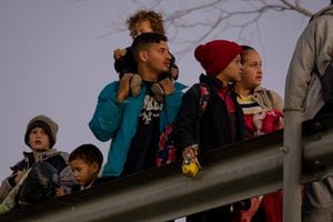 Migrantes, incluido Blaidimar, (i), de 8 años, de Venezuela, pasan la noche afuera a lo largo de la valla fronteriza entre Estados Unidos y México mientras esperan presentar solicitudes de asilo en El Paso, Texas, el 21 de diciembre de 2022