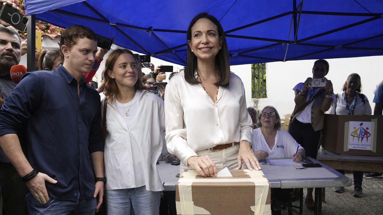 La aspirante presidencial de la oposición María Corina Machado vota durante las elecciones primarias de la oposición mientras sus hijos esperan en Caracas, Venezuela, el domingo 22 de octubre de 2023.