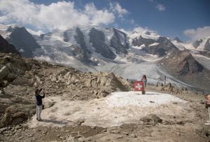 Una mujer posa junto a una bandera nacional suiza cerca del Monte Piz Palue y el glaciar Pers, cerca de la localidad alpina de Pontresina, Suiza, el 21 de julio de 2022.  REUTERS/Arnd Wiegmann