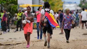 A migrant wears a Venezuelan flag in Necocli, Colombia, a stopping point for migrants taking boats to Acandi which leads to the Darien Gap, Thursday, Oct. 13, 2022. Some Venezuelans are reconsidering their journey to the U.S. after the U.S. government announced on Oct. 12 that Venezuelans who walk or swim across the border will be immediately returned to Mexico without rights to seek asylum. (AP Photo/Fernando Vergara)
