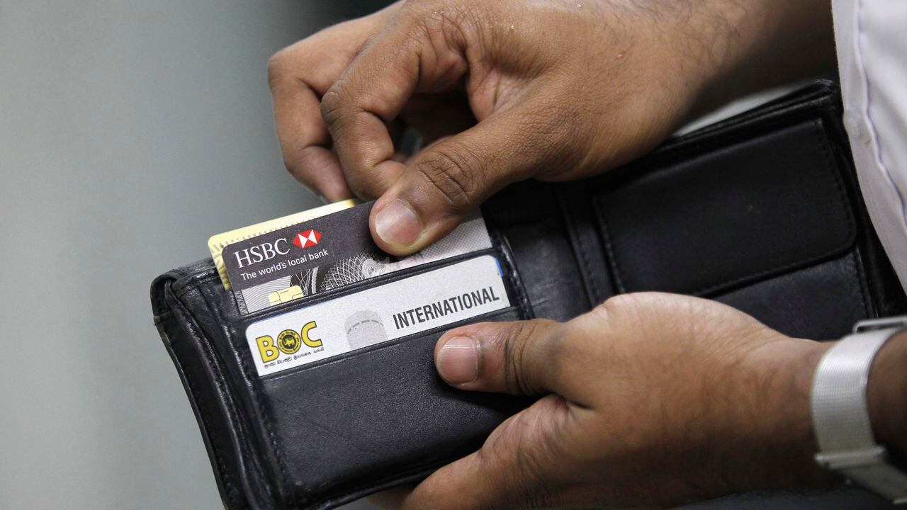 Un hombre saca su tarjeta de crédito para hacer una compra en una tienda. REUTERS / Dinuka Liyanawatte (SRI LANKA - Etiquetas: NEGOCIOS)