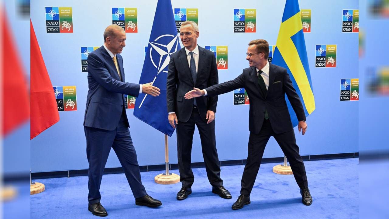 El presidente turco, Tayyip Erdogan, y el primer ministro sueco, Ulf Kristersson, se dan la mano junto al secretario general de la OTAN, Jens Stoltenberg, antes de su reunión, en vísperas de una cumbre.