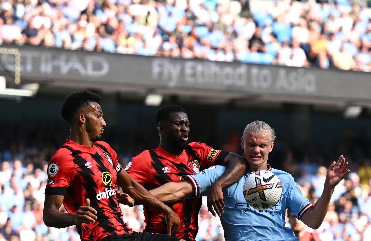 Manchester City's Norwegian striker Erling Haalan (R) fights for the ball with Bournemouth's English defender Lloyd Kelly (L) and Bournemouth's Colombian midfielder Jefferson Lerma (C) during the English Premier League football match between Manchester City and Bournemouth at the Etihad Stadium in Manchester, north west England, on August 13, 2022. (Photo by Oli SCARFF / AFP) / RESTRICTED TO EDITORIAL USE. No use with unauthorized audio, video, data, fixture lists, club/league logos or 'live' services. Online in-match use limited to 120 images. An additional 40 images may be used in extra time. No video emulation. Social media in-match use limited to 120 images. An additional 40 images may be used in extra time. No use in betting publications, games or single club/league/player publications. /