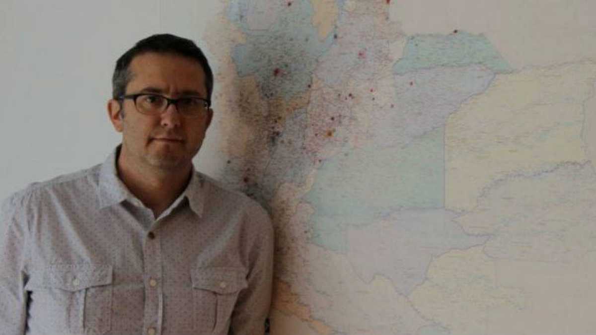 Natalio Cosoy junto al mapa que hay en la oficina de la corresponsalía de BBC Mundo en Colombia.