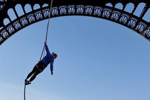 El atleta francés Anouk Garnier calienta antes de subir la cuerda a la Torre Eiffel para batir el récord mundial, en la Torre Eiffel de París