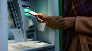 Cerca de una mujer afroamericana retirando dinero de un cajero automático en la ciudad.