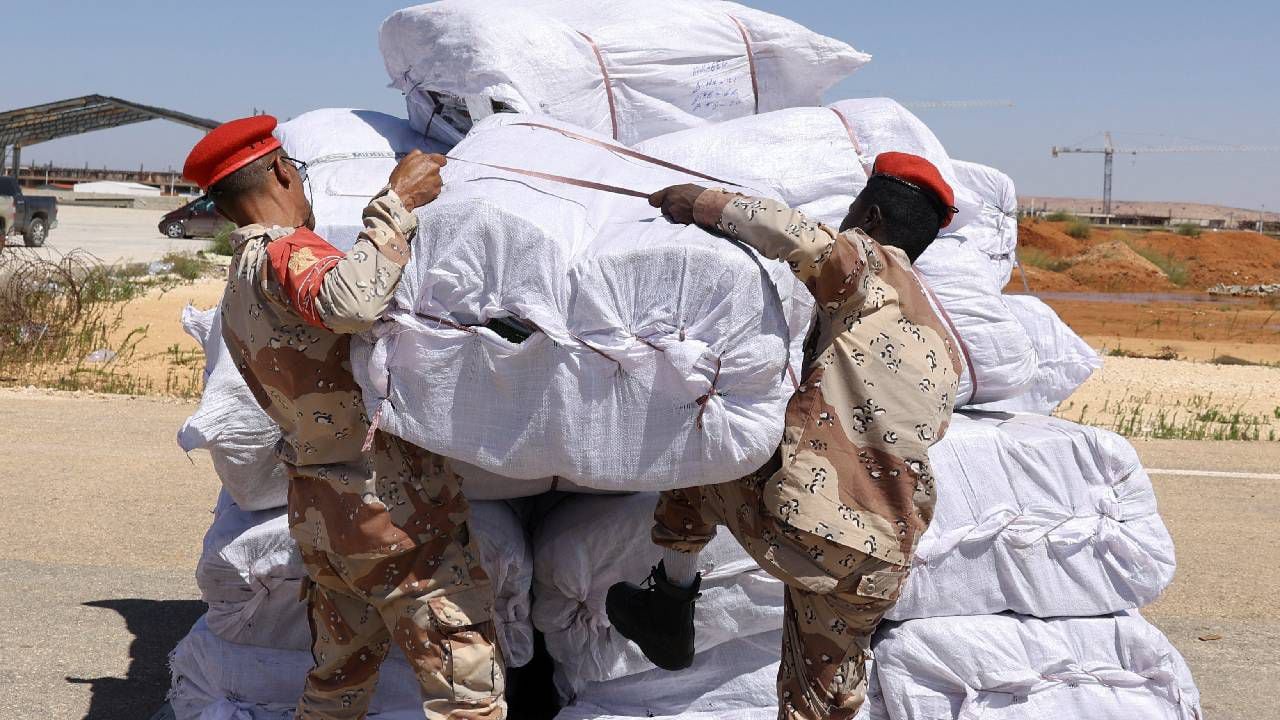 Oficiales militares de Libia manejan artículos de socorro que llegan desde los Emiratos Árabes Unidos.