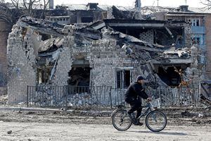 Residente local pasa en bicicleta frente a un edificio destruido durante el conflicto entre Ucrania y Rusia en la ciudad de Volnovakha, controlada por los separatistas, en la región de Donetsk, Ucrania, el 15 de marzo de 2022. Foto REUTERS/Alexander Ermochenko