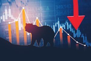 Silhouette of bear walking with declining finance chart and stock market background