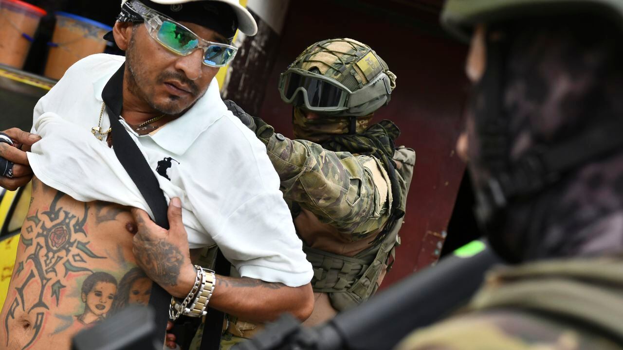 Un soldado examina la espalda de un hombre buscando tatuajes relacionados con pandillas, durante una operación de detención y cacheo en Portoviejo, Ecuador, el jueves 11 de enero de 2024.
