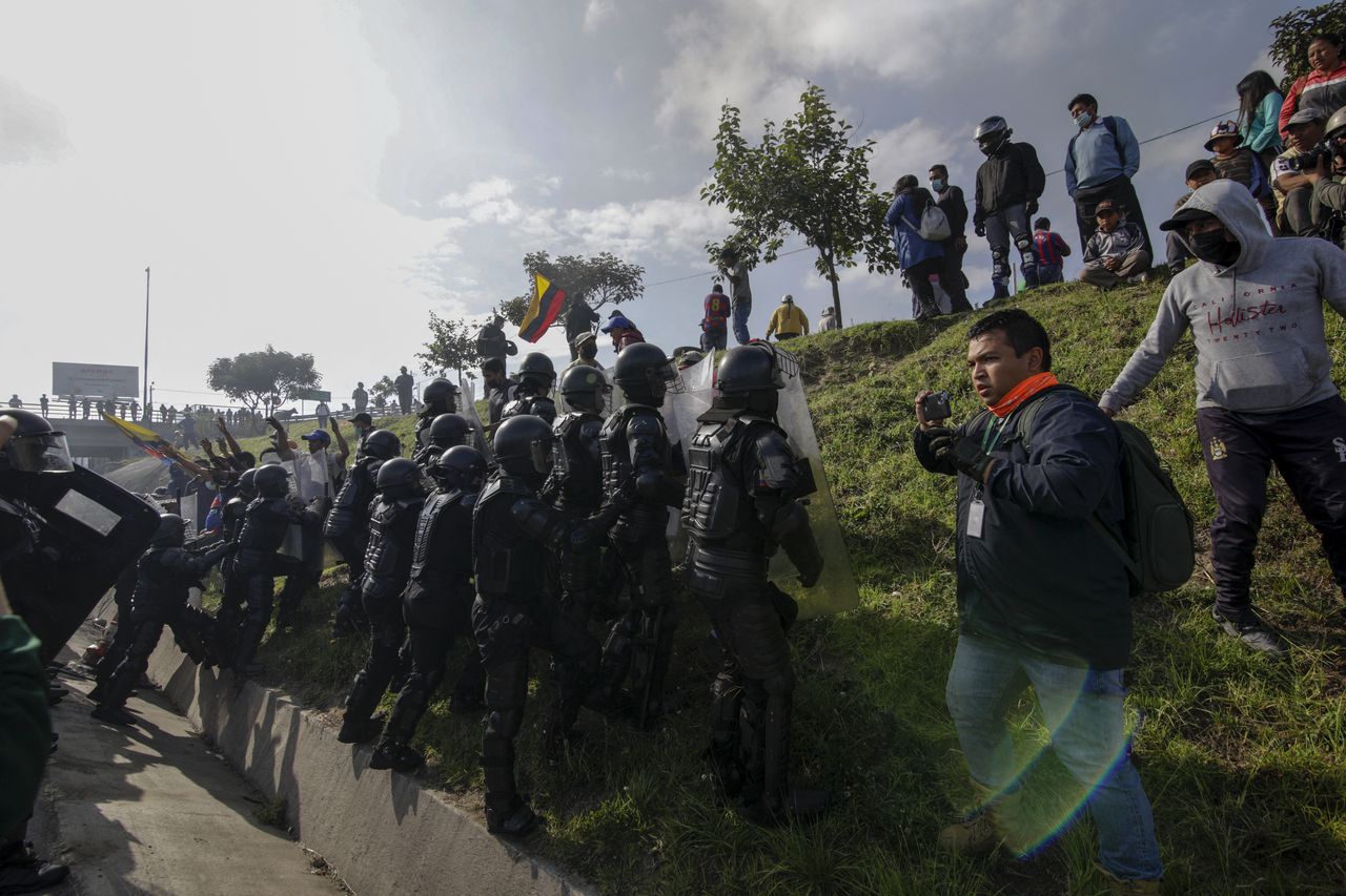 La policía antidisturbios se enfrenta a un manifestante en un bloqueo de carretera en la carretera Ruta Viva, que conduce al aeropuerto Mariscal Sucre, en el marco de protestas lideradas por indígenas contra los altos precios del combustible y el costo de vida, en Quito el 17 de junio de 2022. - Pueblos indígenas, que conforman más de un millón de los 17,7 millones de habitantes de Ecuador, se embarcaron el lunes en una protesta antigubernamental abierta a la que desde entonces se han sumado estudiantes y otros grupos descontentos. (Foto por Cristina Vega RHOR / AFP)
