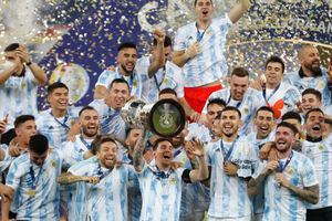El argentino Lionel Messi, centro, sostiene el trofeo mientras celebra con sus compañeros de equipo después de vencer 1-0 a Brasil en la final de la Copa América en el estadio Maracaná de Río de Janeiro, Brasil, el sábado 10 de julio de 2021 (AP Photo / Andre Penner)