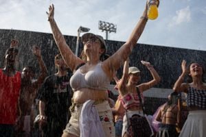 Los y las asistentes al concierto de Taylor Swift han tenido que ser atendidos por los bomberos de Rìos de Janiero, quienes les echan agua por las atltas temperaturas. /Foto Tercio TEIXEIRA / AFP)