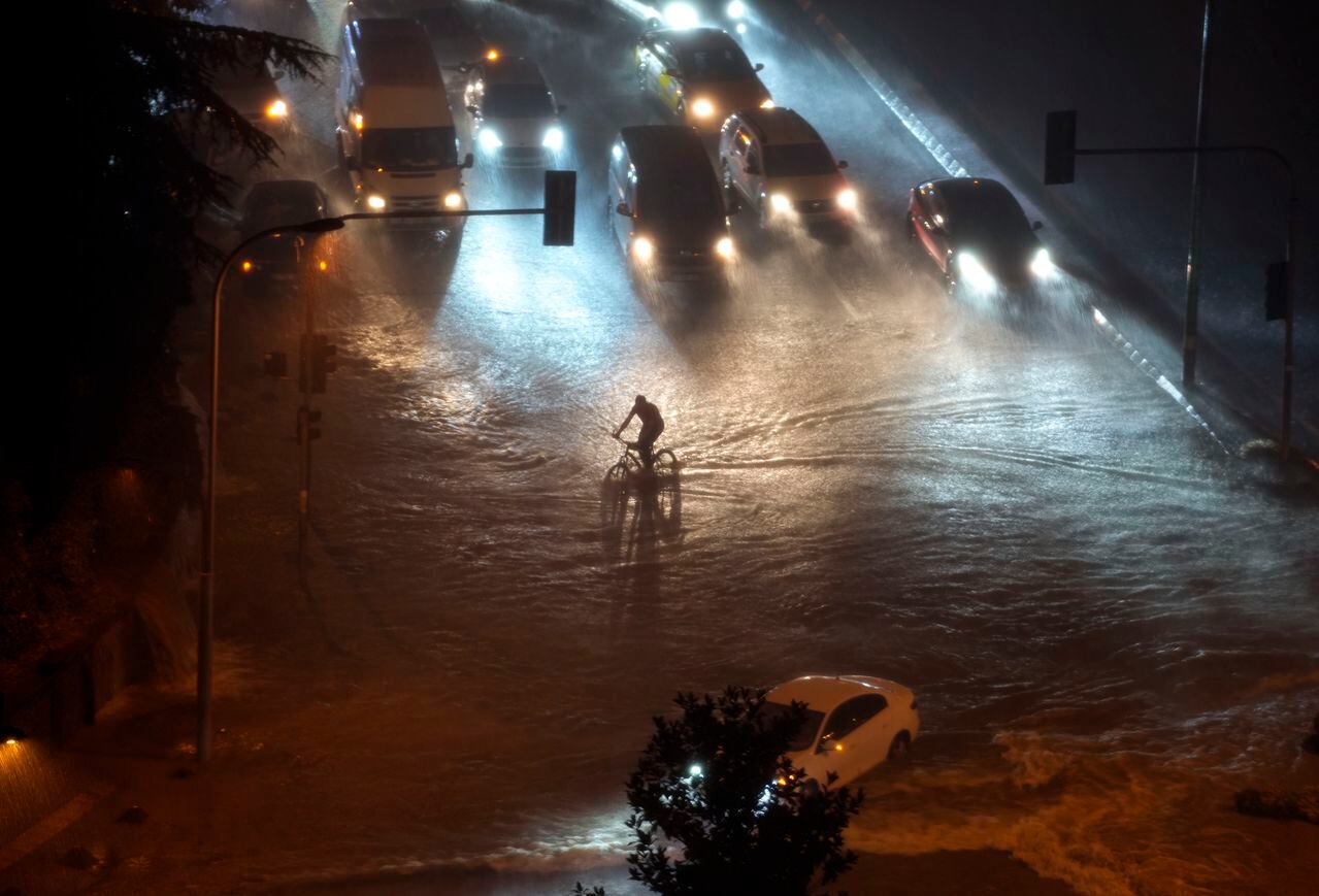 Un ciclista atraviesa las aguas inundadas que bloquean la carretera debido a las fuertes lluvias en el distrito de Basaksehir de Estambul, Turquía, el martes 5 de septiembre de 2023.