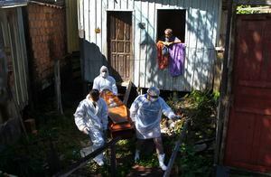 Un familiar observa cómo los trabajadores del servicio funerario público retiran el cuerpo de Amelia Dias Nascimento, de 94 años, quien murió por complicaciones relacionadas con el COVID-19 en su casa, en Manaus, estado de Amazonas.  (Foto AP / Edmar Barros, archivo)