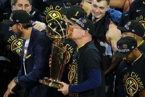 El entrenador en jefe Michael Malone de los Denver Nuggets besa el trofeo del campeonato.