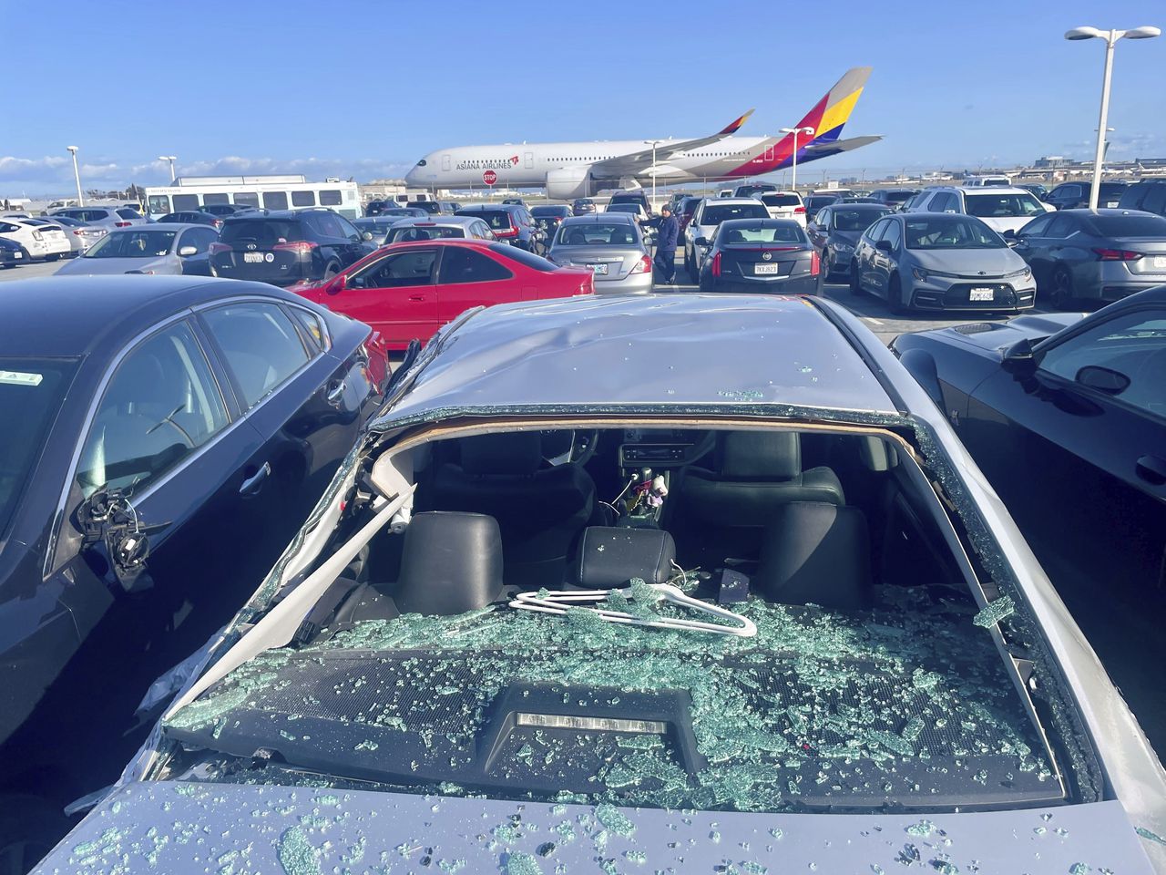 Se ven automóviles dañados en un estacionamiento para empleados del aeropuerto después de que los restos de neumáticos de un Boeing 777 aterrizaran sobre ellos en el Aeropuerto Internacional de San Francisco, el jueves 7 de marzo de 2024.